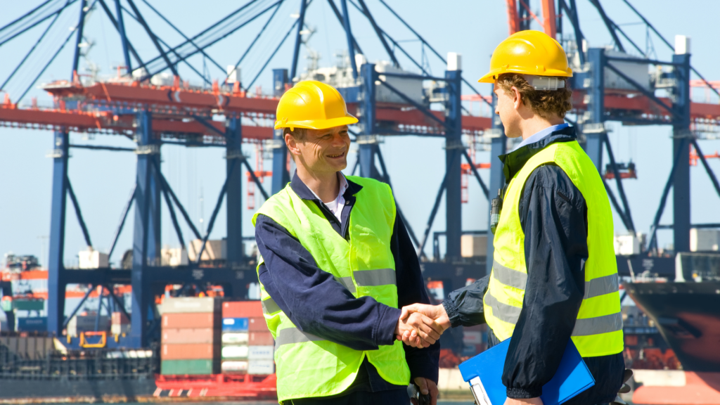 Two safety-clad inspectors shaking hands at petroleum load port following TIC Council China safety code launch